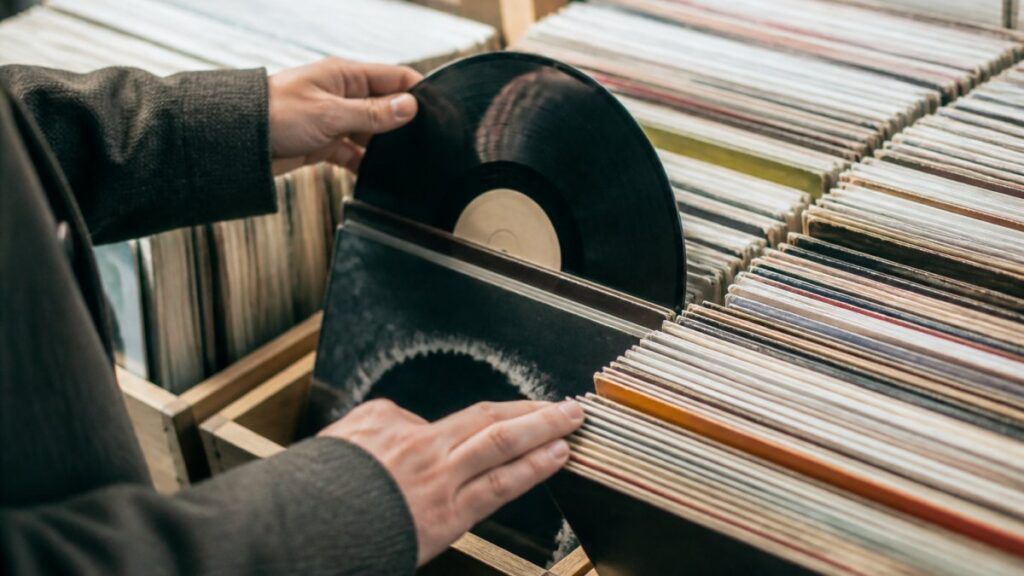Person browsing through vinyl record collection.